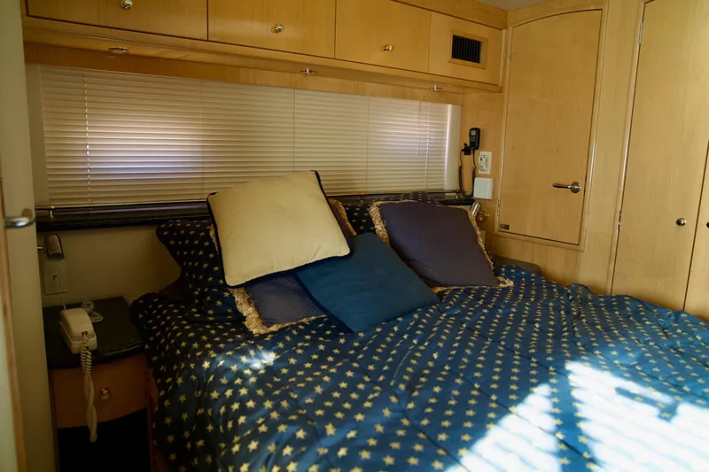  Yacht Photos Pics Cozy bedroom in 2000 Carver 506 Motor Yacht with star-patterned bedding and wooden cabinetry.