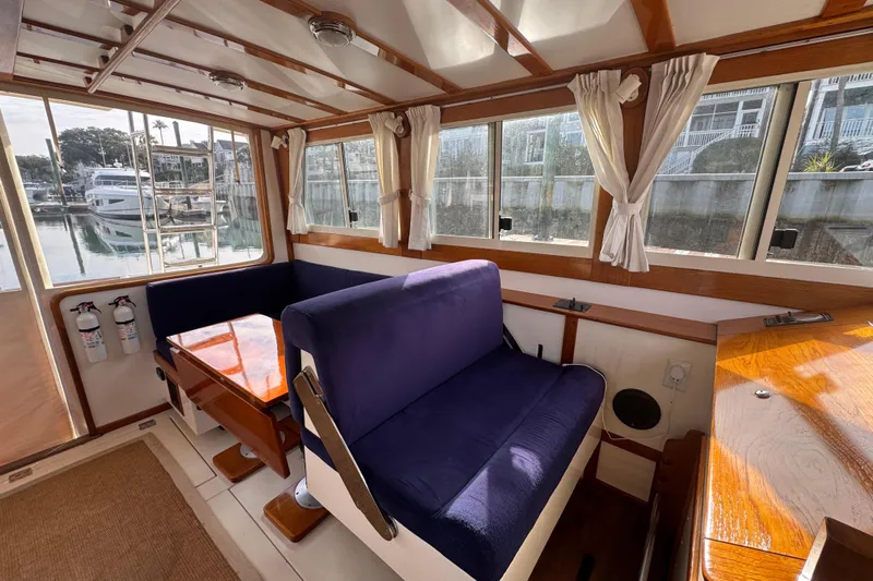 Gullywhumper Yacht Photos Pics Interior of 2001 Ellis 36 Flybridge boat with blue seating and wooden table.