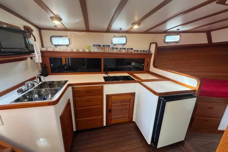 Gullywhumper Yacht Photos Pics 2001 Ellis 36 Flybridge yacht kitchen with wooden cabinetry, sink, stove, and refrigerator.