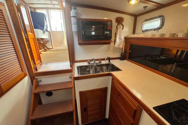 Gullywhumper Yacht Photos Pics 2001 Ellis 36 Flybridge yacht kitchen with wooden cabinetry, sink, and microwave.