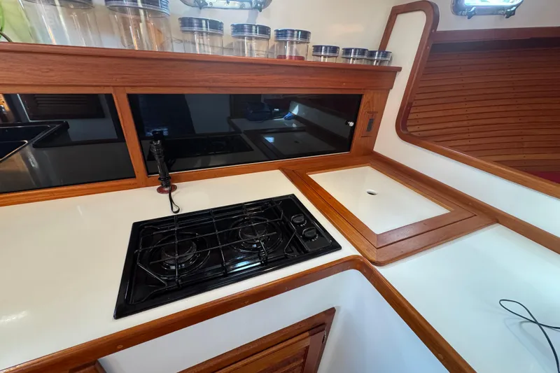 Gullywhumper Yacht Photos Pics 2001 Ellis 36 Flybridge kitchen with stove, sink, and wooden cabinetry.