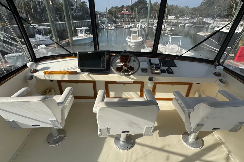 Gullywhumper Yacht Photos Pics Flybridge interior of 2001 Ellis 36, featuring helm, electronics, and three white captain chairs.