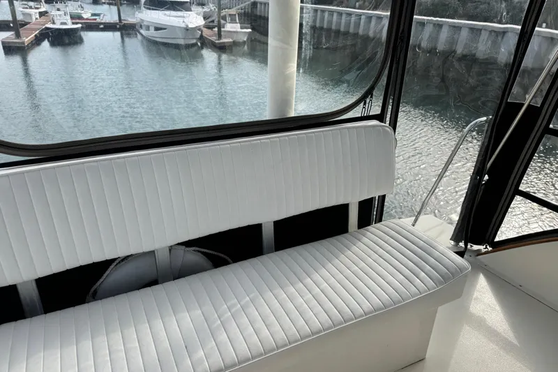 Gullywhumper Yacht Photos Pics Interior view of 2001 Ellis 36 Flybridge with white seating and marina backdrop.
