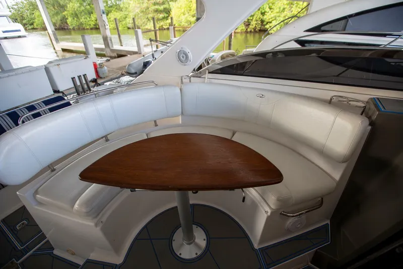  Yacht Photos Pics 2008 Regal 38 yacht interior with curved seating and wooden table.