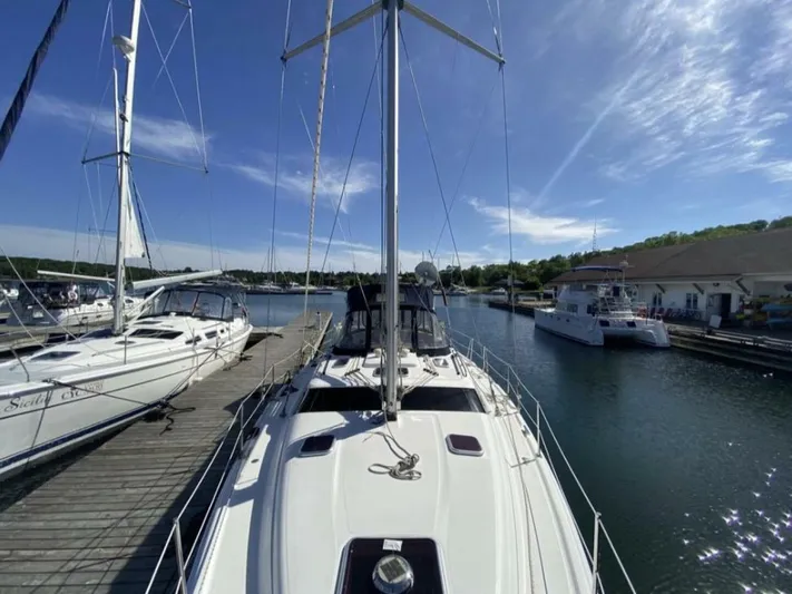  Yacht Photos Pics 2006 Hunter 45 Center Cockpit sailboat docked at a marina under clear blue skies.