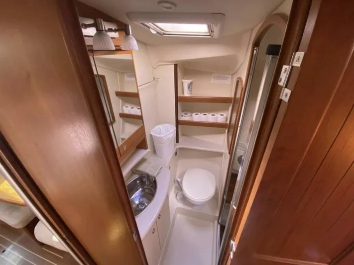  Yacht Photos Pics Bathroom interior of 2006 Hunter 45 Center Cockpit yacht, featuring sink, toilet, and storage shelves.