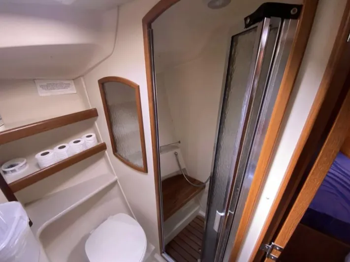  Yacht Photos Pics 2006 Hunter 45 Center Cockpit bathroom with shower, toilet, and storage shelves.