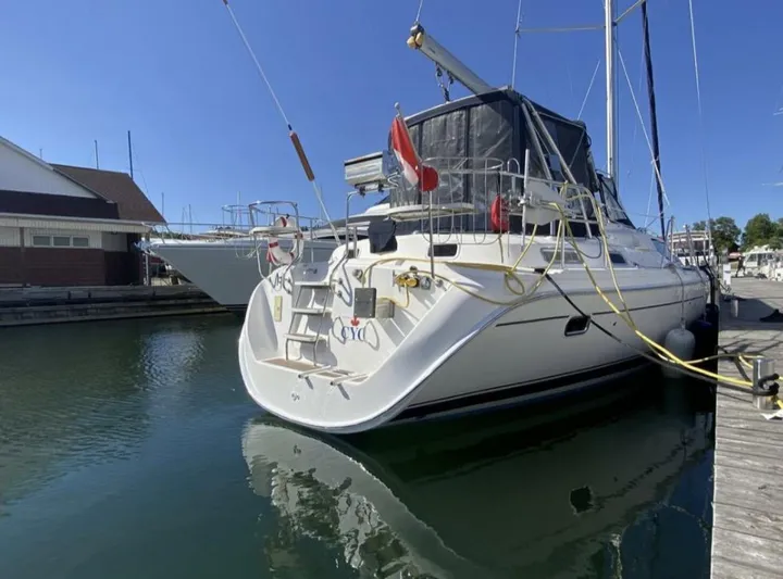  Yacht Photos Pics Hunter 45 Center Cockpit sailboat, 2006 model, docked in a marina under clear blue skies.