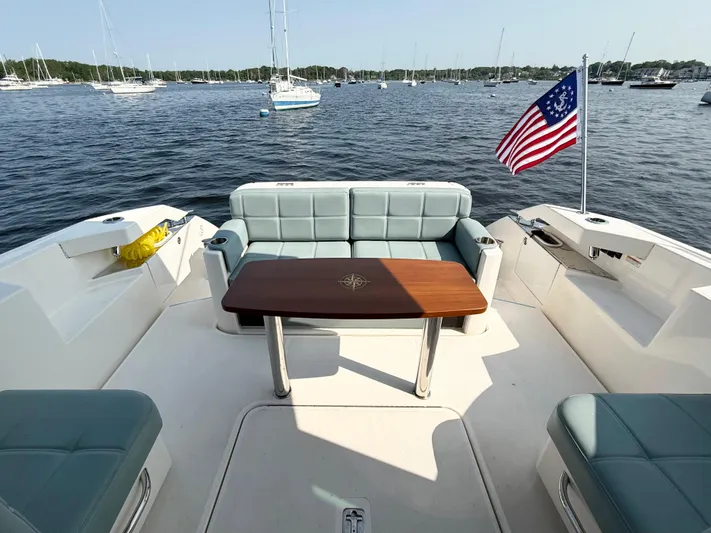 Silver Lining, Name Reserved Yacht Photos Pics 2017 Tiara Yachts 39 Coupe with seating area, table, and American flag on a calm water backdrop.