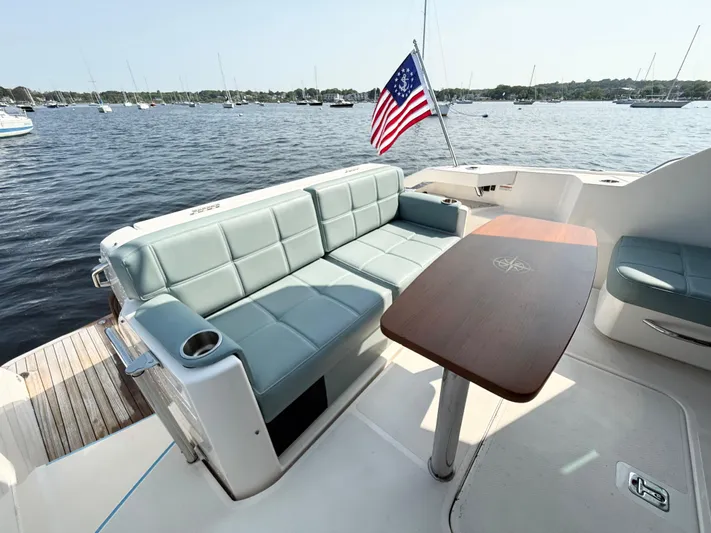 Silver Lining, Name Reserved Yacht Photos Pics 2017 Tiara Yachts 39 Coupe with seating area and table, overlooking a serene waterfront.