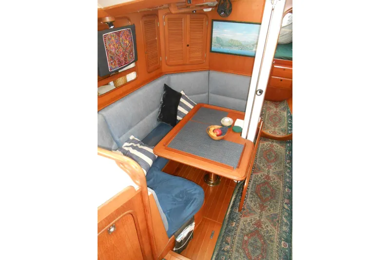 Second Kiss Yacht Photos Pics Cozy interior of 1989 Norseman 447 yacht with dining area and decorative elements.