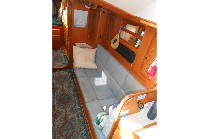 Second Kiss Yacht Photos Pics Cozy interior of 1989 Norseman 447 yacht with blue sofa and wooden accents.