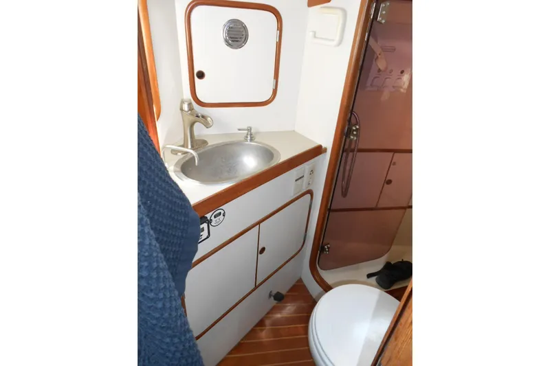 Second Kiss Yacht Photos Pics Compact bathroom in 1989 Norseman 447 yacht with sink, toilet, and shower.