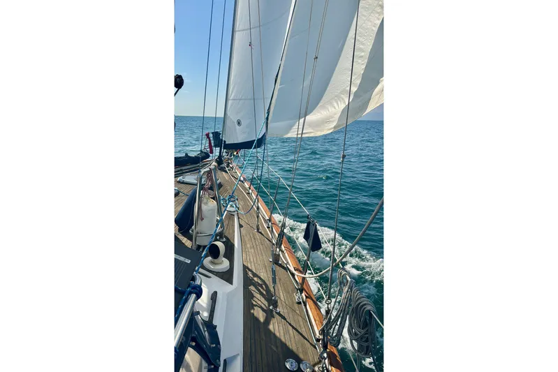 Second Kiss Yacht Photos Pics Sailing on a 1989 Norseman 447 yacht with white sails over blue ocean.