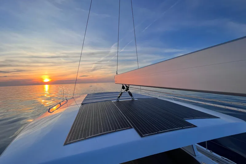  Yacht Photos Pics 2023 Hanse 588 yacht sailing at sunset with solar panels on deck.