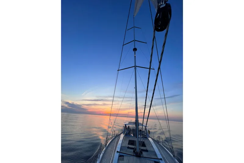  Yacht Photos Pics Sailing on a 2023 Hanse 588 yacht at sunset, calm sea and vibrant sky.