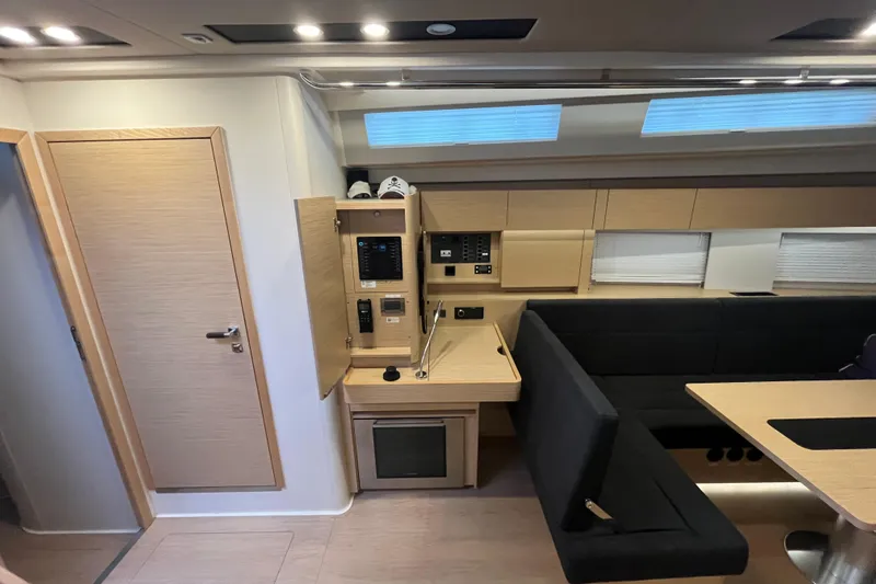  Yacht Photos Pics Modern interior of 2023 Hanse 588 yacht with sleek wood finishes and seating area.