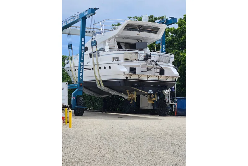 "fortunate" Yacht Photos Pics 1995 JOHNSON 65 Flybridge Motoryacht on lift at marina, undergoing maintenance.