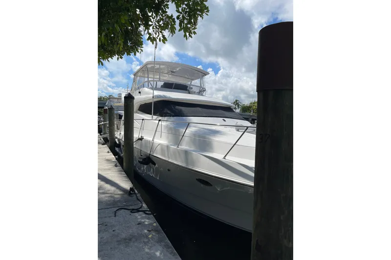 "fortunate" Yacht Photos Pics 1995 JOHNSON 65 Flybridge Motoryacht docked under a partly cloudy sky.