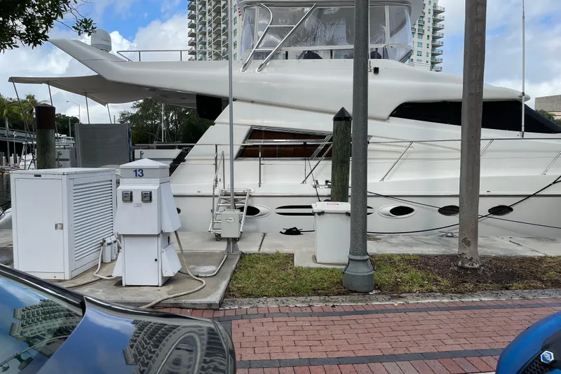 "fortunate" Yacht Photos Pics 1995 JOHNSON 65 Flybridge Motoryacht docked at marina with utility connections.