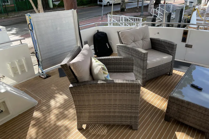 "fortunate" Yacht Photos Pics Flybridge deck of 1995 JOHNSON 65 Motoryacht with wicker seating and table.