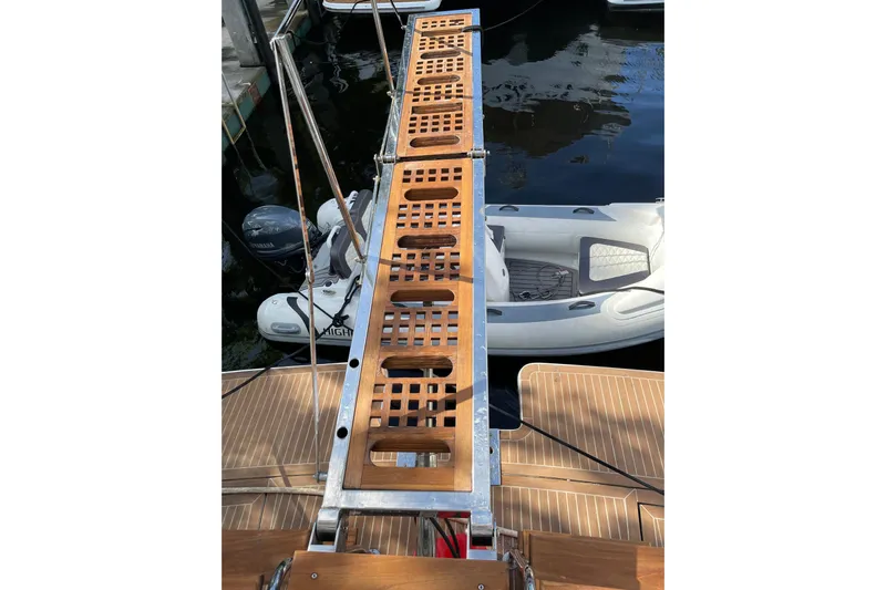 "fortunate" Yacht Photos Pics Teak gangway on 1995 JOHNSON 65 Flybridge Motoryacht, with inflatable boat in background.