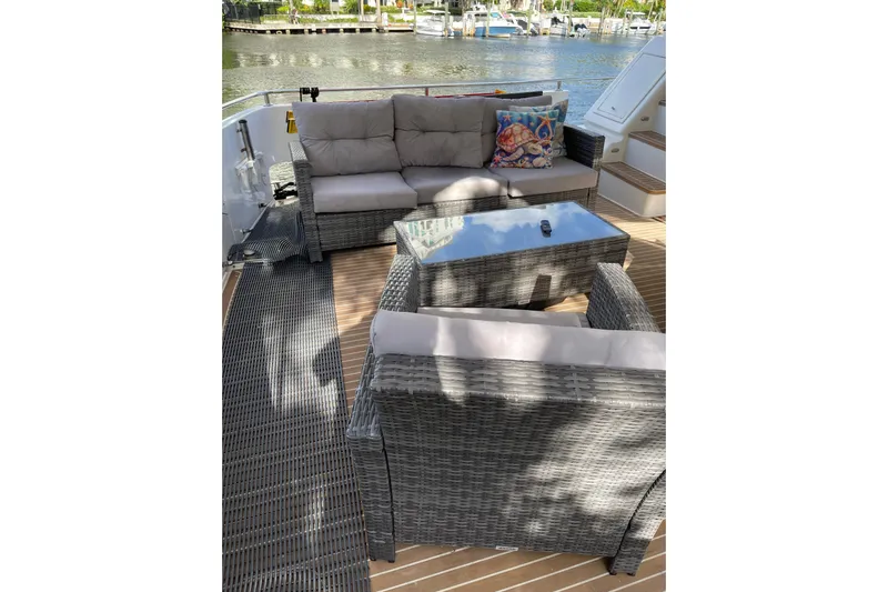 "fortunate" Yacht Photos Pics Outdoor seating area on 1995 JOHNSON 65 Flybridge Motoryacht, featuring wicker furniture and water view.