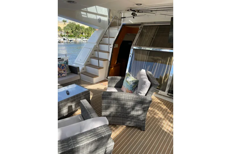 "fortunate" Yacht Photos Pics Luxurious 1995 JOHNSON 65 Flybridge Motoryacht deck with wicker seating and scenic water view.