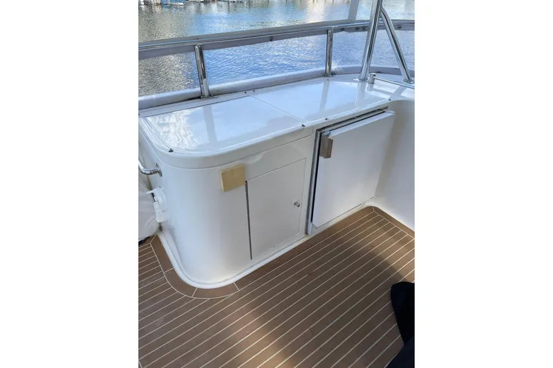 "fortunate" Yacht Photos Pics Flybridge area of 1995 JOHNSON 65 Motoryacht with white cabinetry and wood flooring.