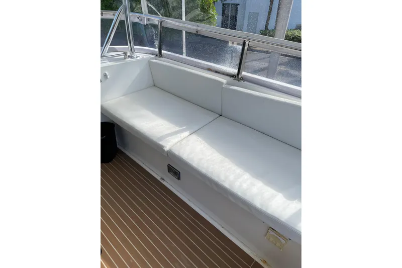 "fortunate" Yacht Photos Pics White cushioned seating on 1995 JOHNSON 65 Flybridge Motoryacht, with wooden deck flooring.