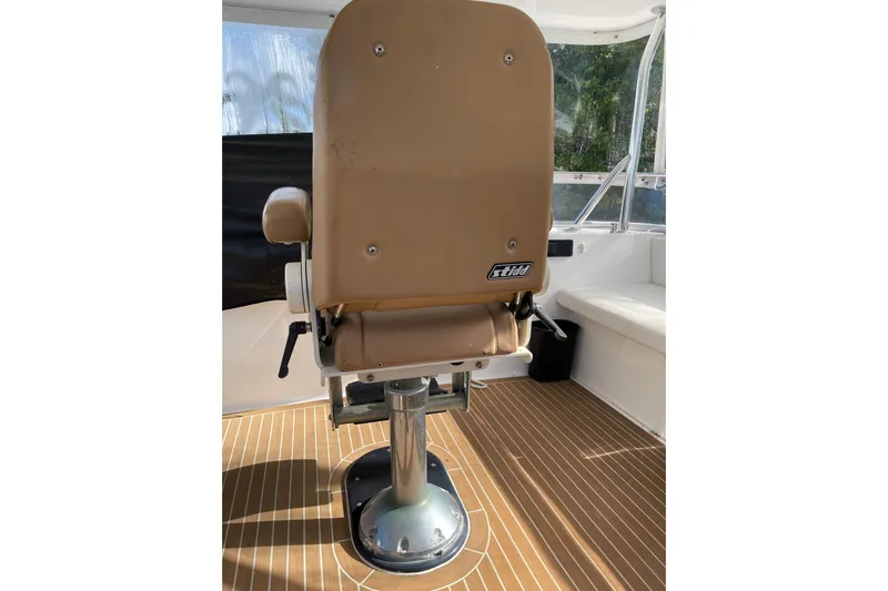 "fortunate" Yacht Photos Pics Captain's chair on 1995 JOHNSON 65 Flybridge Motoryacht, featuring tan upholstery and sturdy base.