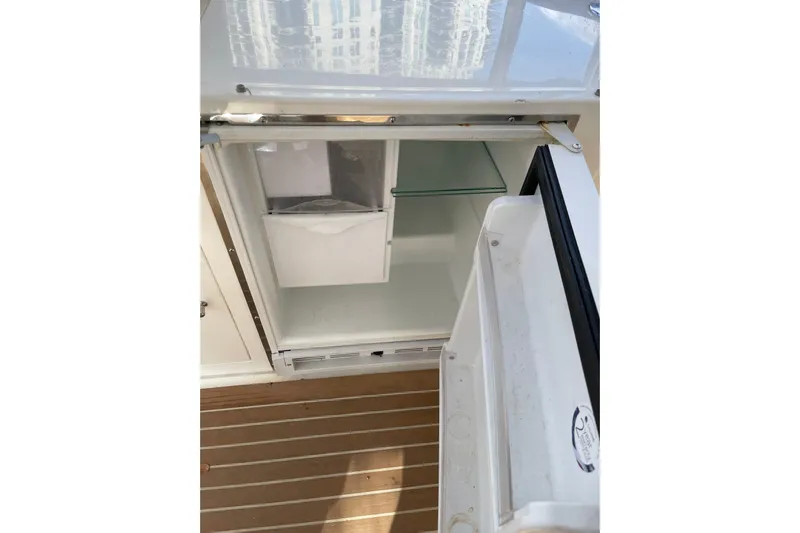 "fortunate" Yacht Photos Pics Open refrigerator on Johnson 65 Flybridge Motoryacht, 1995 model, with wooden flooring.