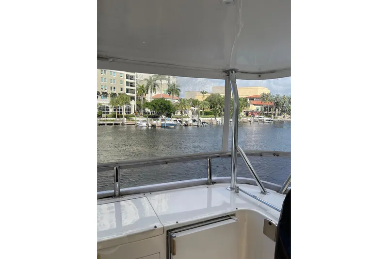"fortunate" Yacht Photos Pics 1995 JOHNSON 65 Flybridge Motoryacht view from deck, overlooking marina and waterfront buildings.