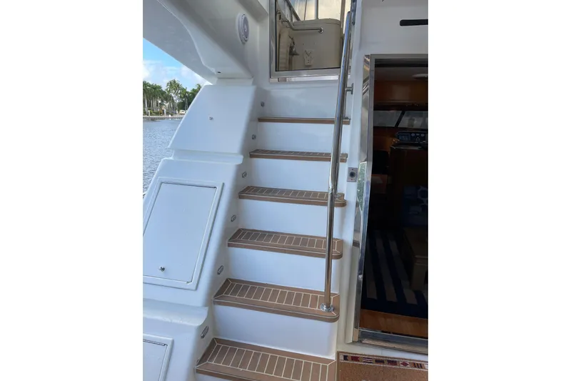 "fortunate" Yacht Photos Pics Staircase on 1995 JOHNSON 65 Flybridge Motoryacht, leading to upper deck with water view.