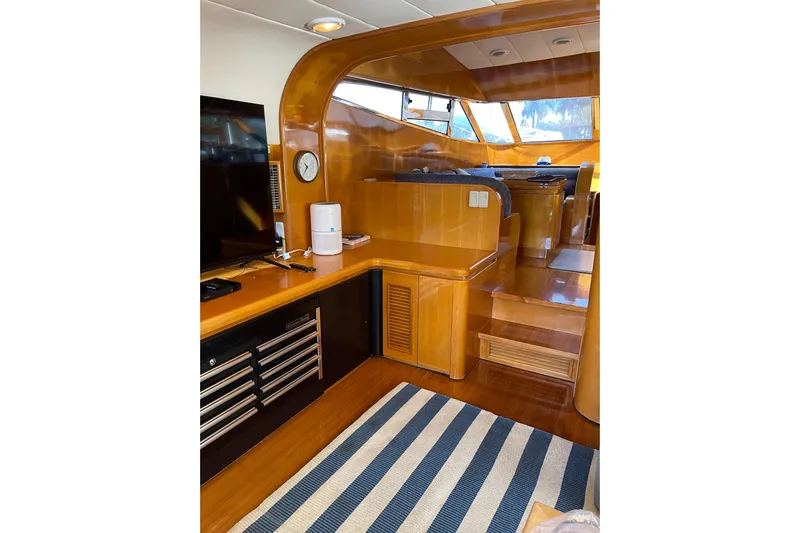 "fortunate" Yacht Photos Pics Interior of 1995 JOHNSON 65 Flybridge Motoryacht with wood finish and striped rug.
