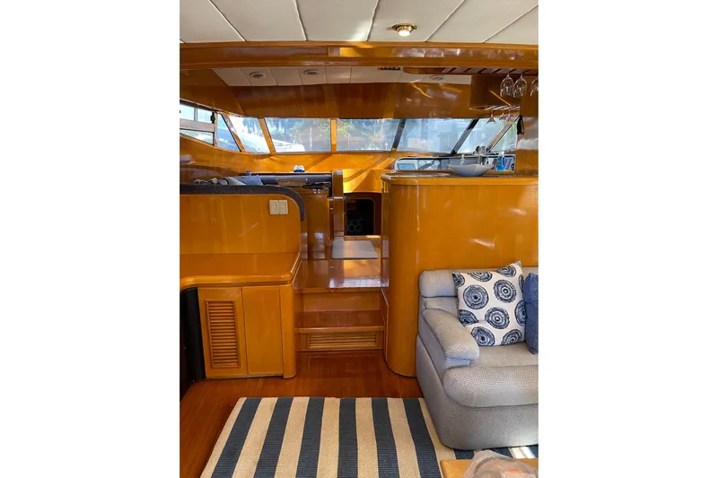 "fortunate" Yacht Photos Pics Interior of 1995 JOHNSON 65 Flybridge Motoryacht with wooden finishes and cozy seating area.