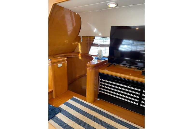 "fortunate" Yacht Photos Pics Interior of 1995 JOHNSON 65 Flybridge Motoryacht with TV and wooden staircase.