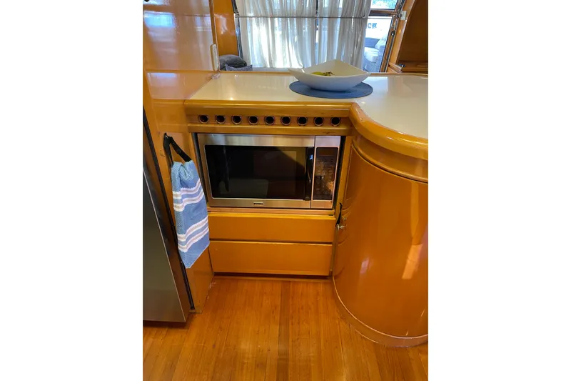 "fortunate" Yacht Photos Pics Luxurious kitchen area in 1995 JOHNSON 65 Flybridge Motoryacht with microwave and wooden cabinetry.