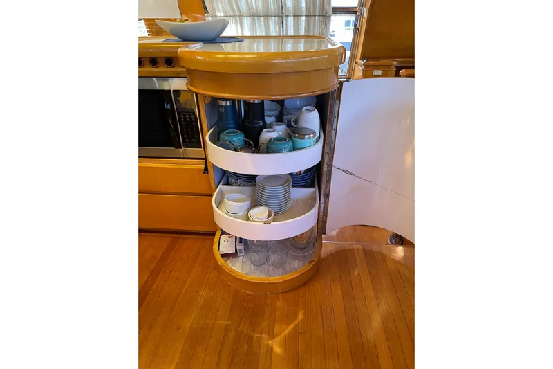 "fortunate" Yacht Photos Pics Open cabinet with dishes and cups on a Johnson 65 Flybridge Motoryacht, 1995 model.