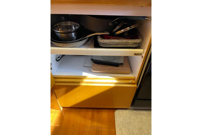 "fortunate" Yacht Photos Pics Kitchen cabinet with cookware and utensils on a 1995 JOHNSON 65 Flybridge Motoryacht.