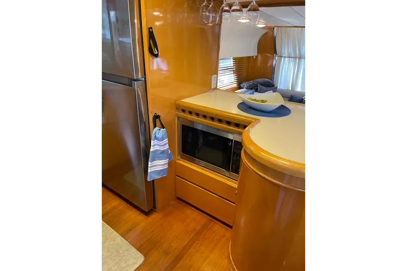 "fortunate" Yacht Photos Pics Kitchen area of 1995 JOHNSON 65 Flybridge Motoryacht with modern appliances and wood finish.