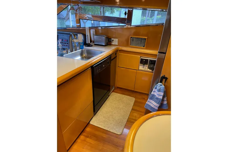 "fortunate" Yacht Photos Pics Kitchen area of 1995 JOHNSON 65 Flybridge Motoryacht with modern appliances and wood cabinetry.