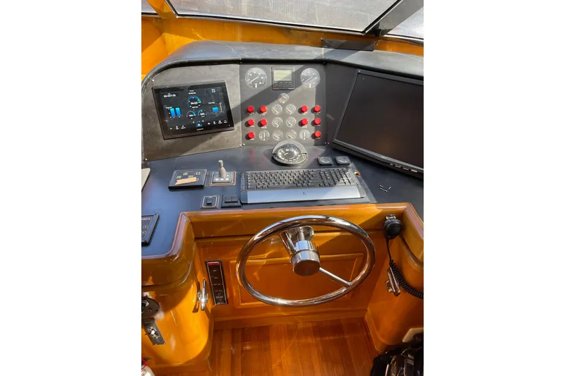 "fortunate" Yacht Photos Pics Control panel of 1995 JOHNSON 65 Flybridge Motoryacht with steering wheel and navigation instruments.