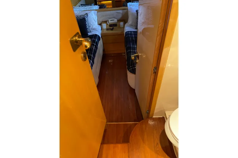 "fortunate" Yacht Photos Pics Interior view of 1995 JOHNSON 65 Flybridge Motoryacht cabin with twin beds and wooden flooring.