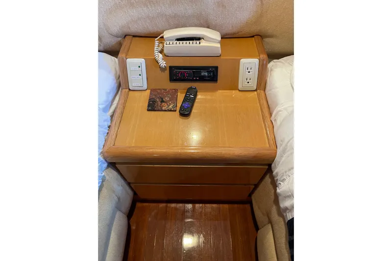 "fortunate" Yacht Photos Pics Wooden nightstand with phone, remote, and outlets on Johnson 65 Flybridge Motoryacht, 1995.
