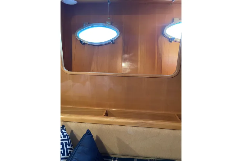 "fortunate" Yacht Photos Pics Interior of 1995 JOHNSON 65 Flybridge Motoryacht with wooden paneling and porthole windows.