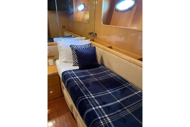 "fortunate" Yacht Photos Pics Cozy cabin interior of 1995 JOHNSON 65 Flybridge Motoryacht with plaid bedding and porthole.