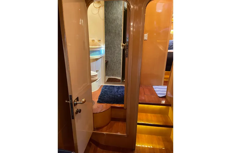 "fortunate" Yacht Photos Pics Interior of 1995 JOHNSON 65 Flybridge Motoryacht, featuring a bathroom and wooden steps.