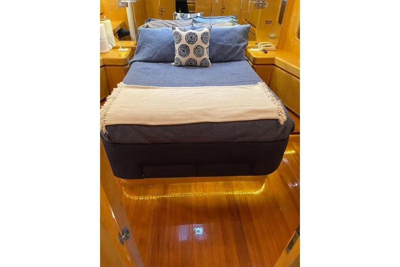 "fortunate" Yacht Photos Pics Luxurious bedroom interior of 1995 JOHNSON 65 Flybridge Motoryacht with elegant bedding and wood finish.