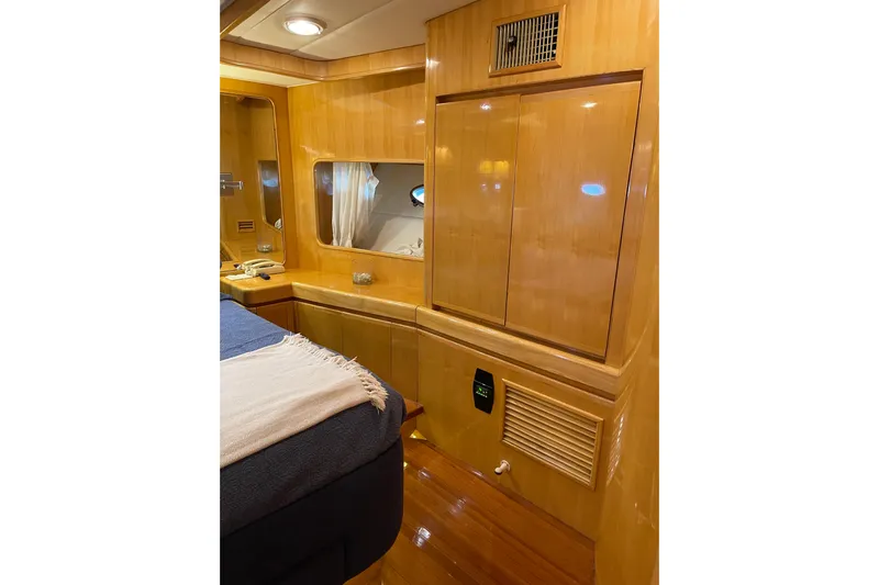 "fortunate" Yacht Photos Pics Luxurious interior of 1995 JOHNSON 65 Flybridge Motoryacht with wood paneling and cozy bedding.